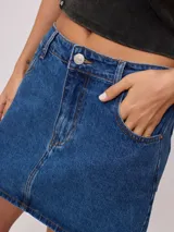 Minifalda de jean azul con bolsillos delanteros y traseros, tiro alto y corte recto.