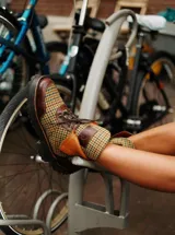 Botas de caña media con plataforma, confeccionadas en tweed a cuadros rojos y negros, con detalles en cuero marrón y cordones marrones.