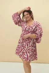 Vestido corto con estampado animal print en tonos verde y blanco, escote en V y mangas 3/4 acampanadas.