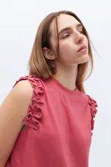 Musculosa color coral de lino con volados en los hombros.