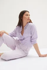 Pantalón de jean estilo baggy, color lila claro, con tiro alto y cierre de botones.