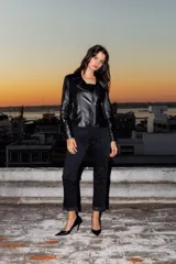 Chaqueta de cuero ovino color negro, con cierre frontal asimétrico y cuello con solapas.