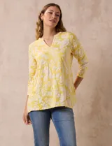 Blusa amarilla con estampado floral blanco, escote en V y mangas 3/4.