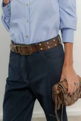 Pantalón de jean azul oscuro de corte recto con detalle de botones dorados en el tobillo.