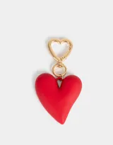 Llavero con dije de corazón rojo y mosquetón dorado en forma de corazón.