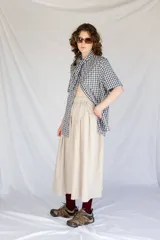 Falda midi negra con cintura elastizada y frunces en los lados.