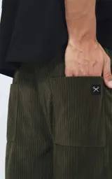 Pantalón cargo de corderoy color verde militar, de calce regular y diseño unisex. Presenta cintura elástica, bolsillos laterales y bolsillos tipo cargo con solapa en los laterales de las piernas.