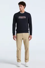 Buzo de tejido de punto color azul marino oscuro, con cuello redondo y puños y ruedo acanalados. Presenta un estampado frontal con el texto "ORIGINAL PENGUIN" en letras con patrón de cuadros multicolor.