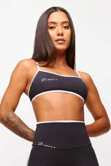 Top deportivo negro con detalles en blanco, logo minimalista y tirantes finos ajustables. Fabricado en poliamida y elastano con protección UV50+.