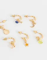 Set de tres pares de aros dorados tipo argolla con dijes colgantes: luna, estrella y cuentas de colores.