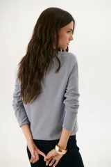 Sweater azul de tejido de punto con cuello redondo y mangas largas.