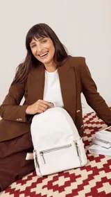 Mochila color tostado combinada con nobuck, bolsillo amplio adelante con broche y cierre, bolsillos en los costados, asas regulables y bolsillos internos cómodos.