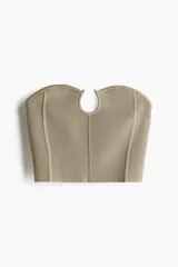 Top strapless corto color beige, en tejido de punto acanalado. Presenta escote corazón con ribete tubular y alambre en U, y costuras decorativas.