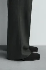 Botín de cuero negro con acabado serraje, cierre de cremallera lateral, horma cuadrada y tacón de 5 cm.