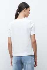 Remera blanca de manga corta con cuello redondo y un estampado frontal que simula una barra de café o té con el texto "TEA D'CLOCK".