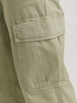 Pantalón cargo color beige, de pierna ancha, tiro medio alto y fit amplio. Cuenta con bolsillos delanteros, traseros y laterales, además de puños ajustables con cordón. Cierre con cremallera.