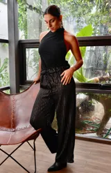 Pantalón negro con lurex plateado a rayas verticales, corte palazzo y cintura elastizada.