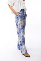 Pantalón fluido con estampado abstracto en tonos azules y blancos, con bolsillos laterales.