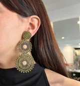 Aros colgantes largos con forma de círculos tramados con cuentas de cristal color turquesa.