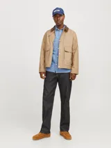 Campera color beige estilo workwear con cuello de pana marrón, cierre frontal con botones a presión, mangas largas y bolsillos frontales con solapa.