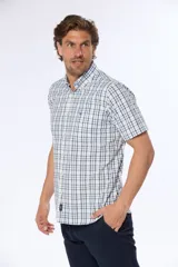 Camisa de manga corta con cuello abotonado y estampado a cuadros en tonos verde y blanco. Hecha en Uruguay.