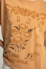 Remera color ocre de corte oversize, con estampado de flores y texto en francés.