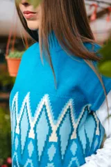 Chaleco de punto morado con cuello alto y diseño geométrico amarillo y azul.