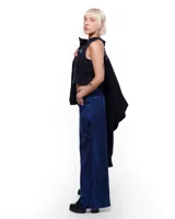 Pantalón de denim azul intenso, corte sastrero de pierna ancha, tiro alto o a la cadera (según el talle elegido), cierre frontal invisible, pretina cruzada y bordado negro del logo Temblad en la parte trasera.