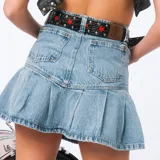 Minifalda de jean celeste con cintura alta, corte recto en la parte superior y falda plisada.