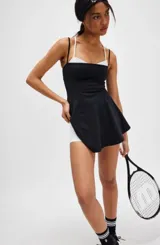 Vestido deportivo de tenis Free People modelo Baseline, color negro con falda acampanada y short blanco debajo. Tirantes finos negros y blancos. Incluye vincha negra.
