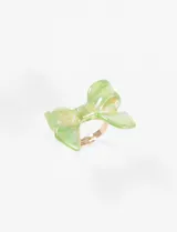 Anillo con diseño de moño en tono verde, elaborado en una mezcla de zinc y cobre.