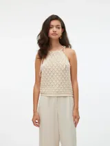 Top de punto color crema, con cuello halter y tiras finas para atar en el cuello.