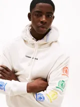 Buzo con capucha blanco de Tommy Jeans, corte amplio, con logo bordado en el pecho, logo del escudo en la espalda y escudos estampados en las mangas.