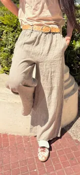 Pantalón marrón de lino con bordados blancos en los laterales y bolsillos. Corte recto y cintura con elástico.