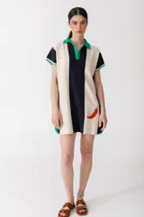 Vestido corto tipo polo con rayas verticales en crudo y azul marino, detalles en verde en cuello y mangas, y bordado de un ají rojo en el frente.