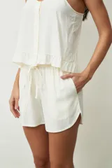 Short negro de tiro alto con cordón ajustable en la cintura y bolsillos laterales. Presenta un corte holgado y ruedos redondeados.