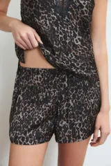 Conjunto de pijama de satén color rojo, compuesto por un top con breteles finos y escote en V adornado con puntilla, y un short con cintura elastizada y lazo regulable.