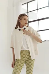 Pantalón acampanado con estampado abstracto en tonos verde y dorado.