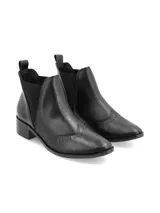 Botín Chelsea de cuero negro con elásticos laterales texturados, punta semi-redondeada, taco bajo y detalles Oxford. Fabricado en Brasil.