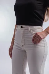 Pantalón de jean blanco de corte recto y tiro alto, con costuras a la vista en color crudo.