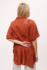 Camisa blanca de manga corta con cuello clásico, corte holgado y detalle de calado vertical en el frente.