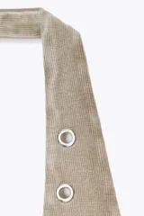 Camiseta blanca de rib con efecto lavado, cuello halter y escote redondo. Detalle de arandelas metálicas en el escote.