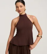 Blusa marrón oscuro con cuello halter y corte peplum, ajustada al cuerpo con pences frontales.