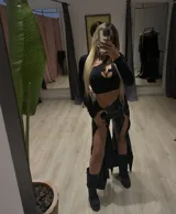 Pantalón negro de cuero sintético con cierres plateados en la parte delantera de las piernas que se abren en su totalidad.