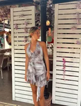 Minivestido con estampado animal print en tonos grises y marrones, con escote halter y volados en el frente.