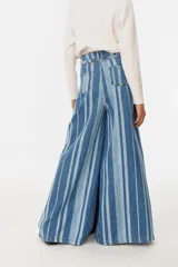 Pantalón de jean de corte amplio con rayas verticales azules y blancas.