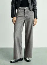Pantalón de jean gris de corte wideleg, tiro medio, cinco bolsillos y cierre con botones.