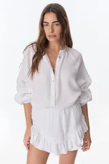 Short pollera blanco de tela arrugada con volados y detalles de encaje.