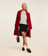 Remera boxy de algodón y poliéster a rayas horizontales blancas y negras, con cuello redondo y mangas cortas. Estampa frontal con la palabra "Darling" en color rojo.