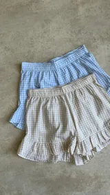 Short a cuadros celestes y blancos con volados en el ruedo.